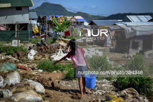 A girl makes her way home after fetching water at a coastal village one year since Typhoon Haiyan hit in Tacloban, Leyte province, Philippin...