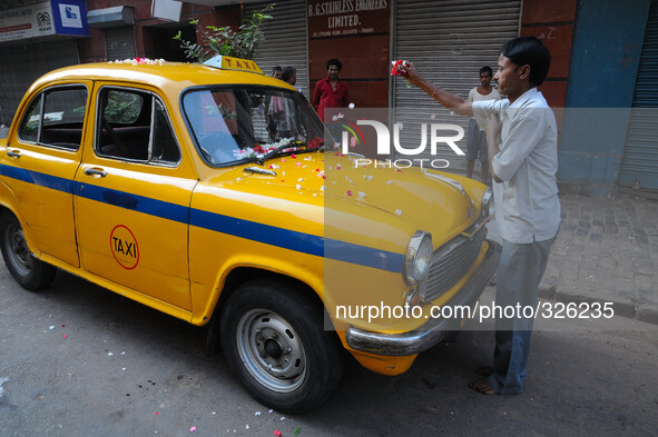 A hindu Taxi Diver Om Prakash Prasad pray her Yellow Ambassador taxis  before join her daily work at Kolkata Street  on November 07,2014. Th...