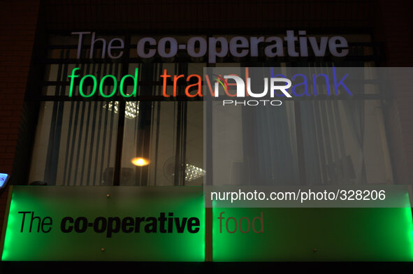 The colours of The Co-Operative group shining from a store, in central Manchester, through the late autumn darkness. 