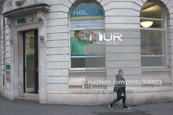 A woman walking on the street, as she passes the HBL bank in central Manchester. 