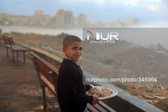  A Palestinian child seller at the shore of the sea in Gaza City, which is experiencing low pressure and rain. 