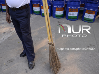 A volunteer waiting with brooms to start the cleaning during Clean India Campaign in Kolkata, India. (