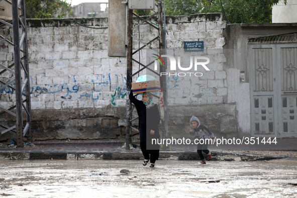 woman walks the street during rain 'has hit Gaza very low in the past 3 days and so far