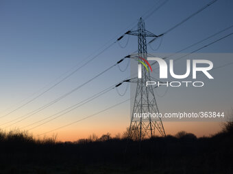 Electricity transmission lines silhouetted against the light of the setting sun on December 5, 2014 in Stockport, England, UK.
(