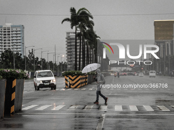 Pasay City, Philippines - A man crosses the road on his way home as Typhoon Hagupit (locally known as Ruby) approaches Manila on Monday, Dec...