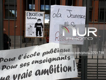 A placard on the metal gate of the Local Board of Education of Toulouse reads 'Youths don't resign themselves' and a banner reads 'For a pub...