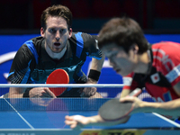 Mengel Steffen (Top) of Germany competes with Mizutani Jun of Japan during Men's single quarter final round of the 2014 ITTF World Tour Gran...