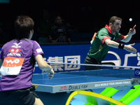 Marcos Freitas of Portugal (Top) competes with Mizutani Jun of Japan during Men's single semi-final round of the 2014 ITTF World Tour Grand...