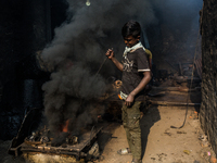 A child worker works in a metal shop near shipyard where he breaks metal small pieces and puts them into the furnace. Dhaka, Bangladesh, Feb...