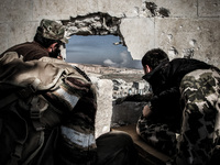 A group of rebels who monitor sites the regime forces during shelling it by mortars and hell cannon, in Aleppo,on December 17, 2014.  (