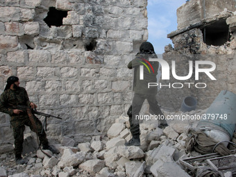 Two of the rebels take turns shooting on regime forces, in Aleppo, Syria, on December 18, 2014. (