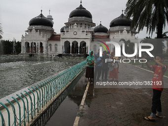 The people of Aceh enjoy the atmosphere around the Mosque Baiturrahman left when the tsunami hit a decade ago in Banda Aceh, capital of Aceh...