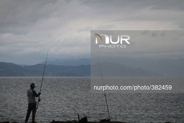 Acehnese men enjoy the atmosphere of coastal waters Ulee Lheue while fishing in Banda Aceh, Indonesia, on December 26, 2014. On December 26,...