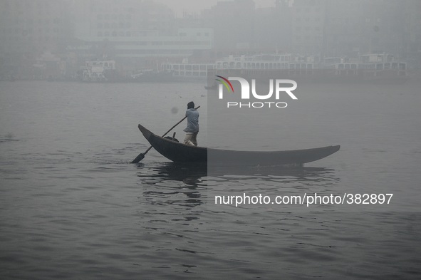 Due to extreme fog a boatman is struggling in the middle of Buriganga River near Dhaka, Bangladesh on 29th September 2014.