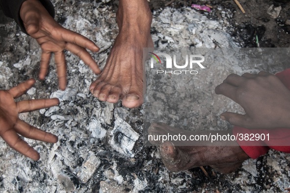 Homeless people are trying to warm themselves by fire on the street at Dhaka, Bangladesh on 29th September 2014.