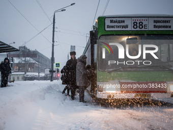 Passengers are forced to walk on the roadway to board the bus, in Kharkov, Ukraine, on December 30, 2014. (