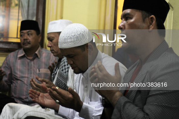 Indonesian men pray for the victims of airline Air Asia flight QZ 8501 were found during a prayer in Medan, North Sumatra, Indonesia, on Dec...