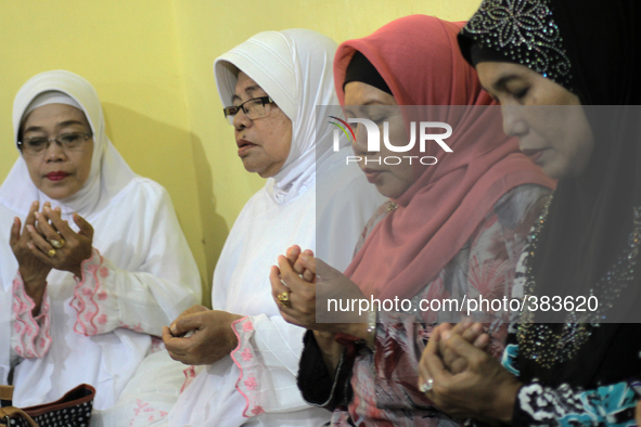 Indonesian women pray for the victims of airline Air Asia flight QZ 8501 were found during a prayer in Medan, North Sumatra, Indonesia, on D...