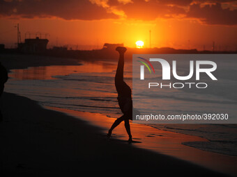 Palestinian man Play on the shore of the Sea of Gaza City at sunset (