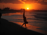 Palestinian man Play on the shore of the Sea of Gaza City at sunset (