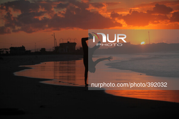 Palestinian man Play on the shore of the Sea of Gaza City at sunset 