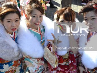 Japanese women in kimonos pose for pictures after a ceremony celebrating Coming of Age Day in Tokyo January 12, 2015.  Age twenty is conside...