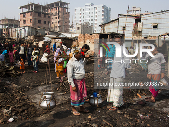 A volunteer was distributing drinking water to the victims at Poolpar Slum  on January 13, 2015 in Dhaka, Bangladesh. (