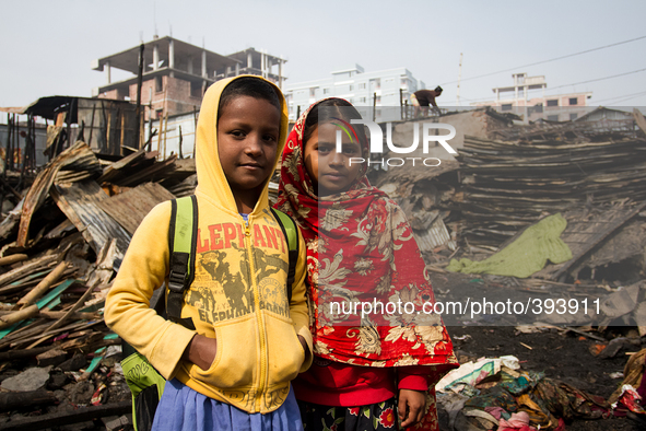 Two friend returned from school but do not have any places to go. They smiles happily amid the remains of the gutted Poolpar Slum in Dhaka,...