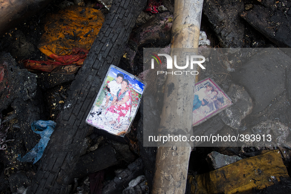 Two photographs of the victims families are found amid the remains of gutted Poolpar Slum  on January 13, 2015 in Dhaka, Bangladesh. 
