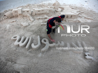 A Palestinian man creates a sand sculpture read ''Except Prophet Mohammed'' at the beach of Gaza city, January 14, 2015, in protest against...