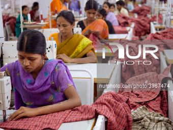 Textile workers making clothing in Bangalore. Many of the workers emigrate from poor regions of the country, making clothes to be sold in th...