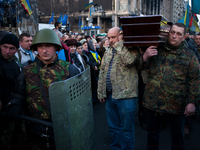 People carrying the coffin of a body of a dead anti-government demonstrator killed in yesterdays clashes with police is lifted above the cro...