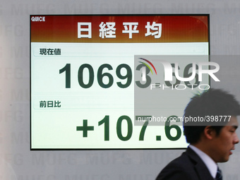 A man walks past a stock quotation board outside a brokerage in Tokyo January 18, 2015. (