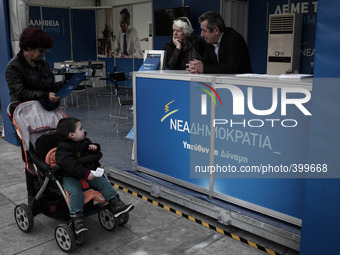 A woman with her child reading a flyer at the New Democracy election campaign kiosk at Syntagma Square in Athens on January 18, 2015. (
