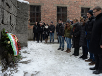 Sylvia Lohrmann (standing third from left), German Minister for Education, surrounded by young students, lays a wreath at the Death Wall nea...