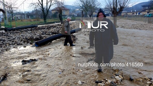 People try to cross the flooded and destroyed streets in the village of Doliste, north-east of the Bulgarian capital Sofia, Sunday, Feb. 01,...