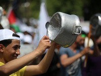 Palestinians  bang on pots during a rally marking International Workers' Day, or Labour Day, in Gaza City May 1, 2019. 
 (