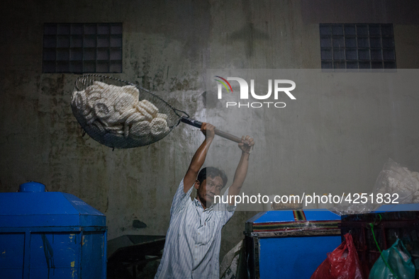 A man carries a basket full with kerupuk or crackers after frying them at a kerupuk factory in Depok, Indonesia, 01 May, 2019. Despite the g...