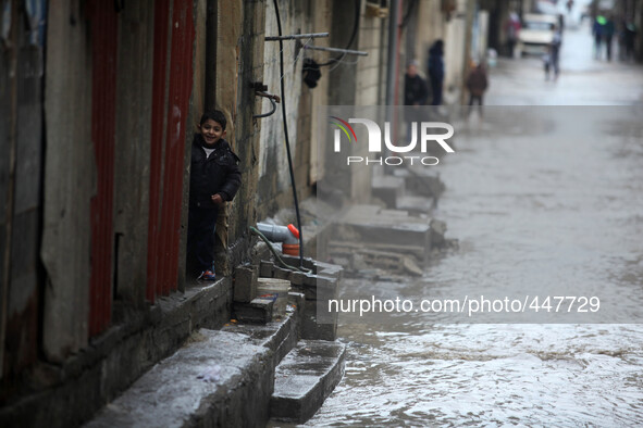 A Palestinian boy look out from their family's house during heavy rains  in Shati refugee camp during a rain storm in Gaza City, Thursday, F...