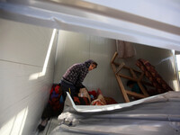 A Palestinian Child Inspects a container as a temporary replacement for their house that was destroyed by what they said was Israeli shellin...