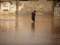 Palestinians Bedouin walks through muddy waters after heavy rains which flooded the Al Moghraka area in the central Gaza Strip. Israeli auth...