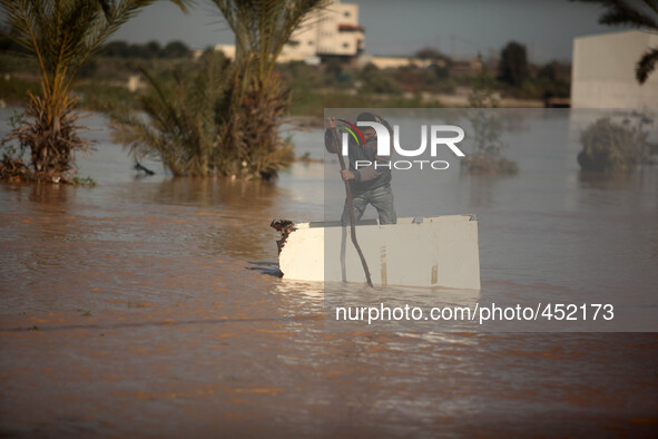  Palestinian Bedouin boy climbs on container through muddy waters after heavy rains which flooded the Al Moghraka area in the central Gaza S...