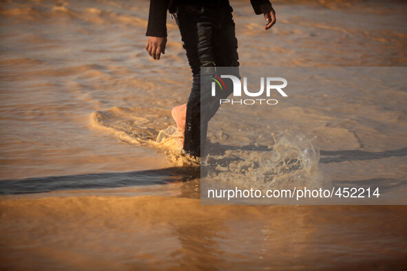 A Palestinian Bedouin boy makes his way despite the water in an area that is flooded after Israel opened the gates of a dam along its border...