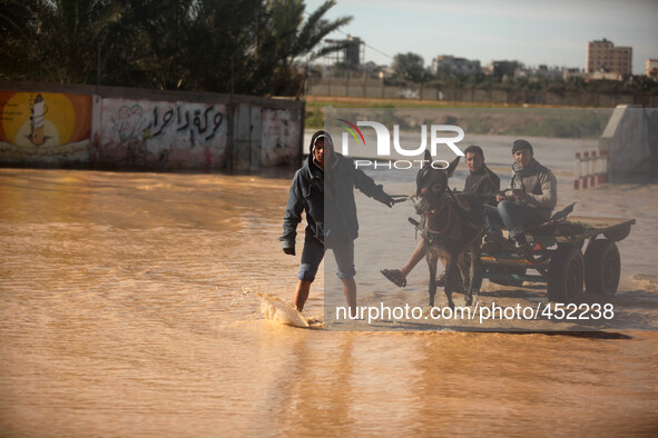 Palestinian Bedouins ride a cart on a road that is flooded after Israel opened the gates of a dam along its border with the Gaza Strip on Fe...