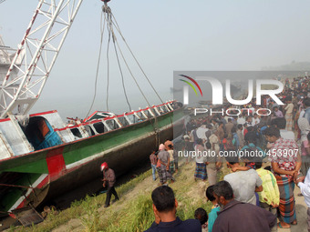 Bangladesh fire service scuba divers stand on a ferry as they try to fix wires from a crane to lift it after it capsized at Paturia some 70...