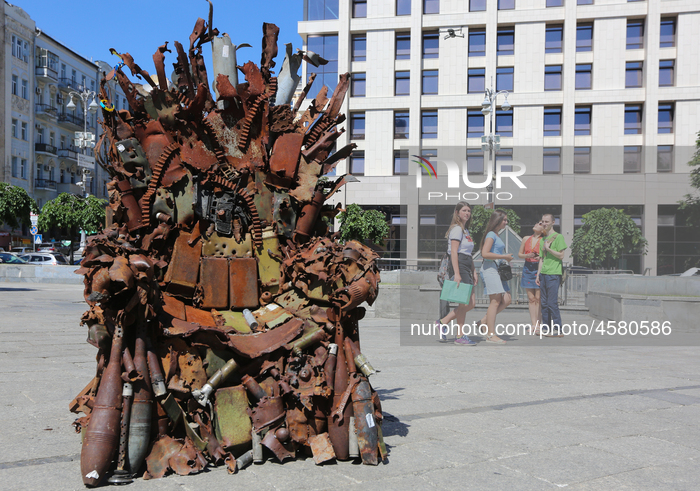 People walk past the iron Throne installed at Independence Square in Kyiv,  Ukraine,  June 25, 2019. 