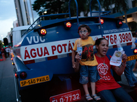 A woman with a child protest in front of a water truck, against the lack of water and in favor of government measures to contain the water c...
