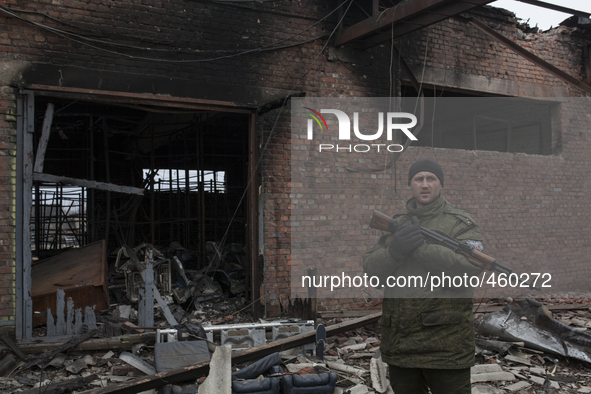 An armed rebel walks past a damaged building in destroyed airport of the eastern Ukrainian city of Donetsk on February 26, 2015. Ukraine's m...