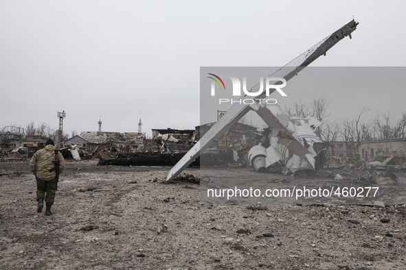 An armed fighter of self-proclamed People's Republic of Donetsk walks past a damaged airplane in the destroyed airport of the eastern Ukrain...