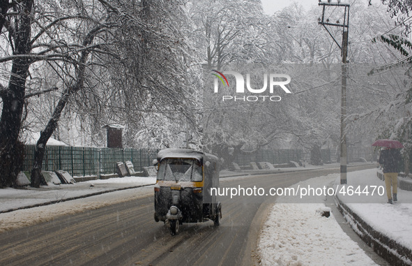 SRINAGAR, INDIAN ADMINISTERED KASHMIR, INDIA - MARCH 02: A vehicle moves on a snow covered road during a fresh snowfall on March 2, 2015 in...